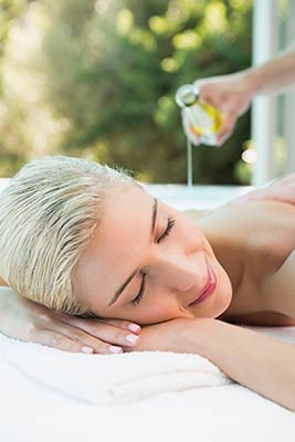 Frau entspannt bei Massage mit Aromaölen