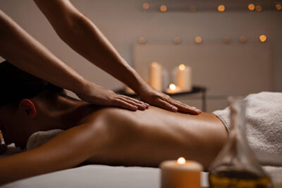 Sanfte ASMR Ganzkörpermassage am Rücken mit Kerzen und Massageöl in entspannter Wellness-Atmosphäre